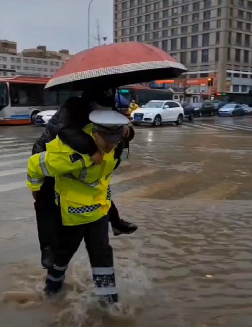 郑州暴雨交警蹚水抱孩子过马路，暖心救援行动感动网友