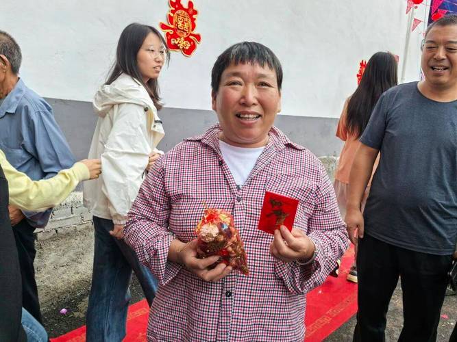 村民抛撒糍粑红包分享新房封顶喜悦